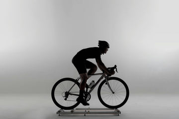 A cyclist on a scenic road, with icons representing strength training, swimming, and running, illustrating the concept of cross-training for cyclists.